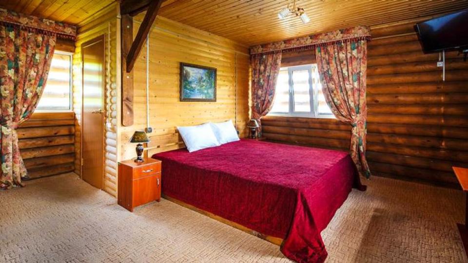 Кровать в трехместном номере в деревянном коттедже в пансионате Гольфстрим в Анапе
